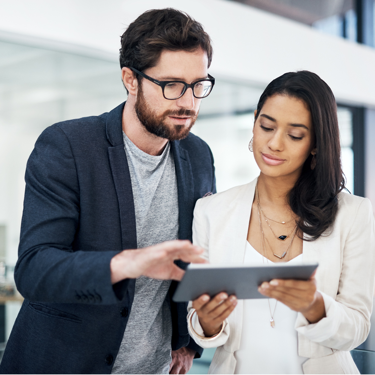 A man and a woman look at the Medicare Vision Insights Report on a tablet