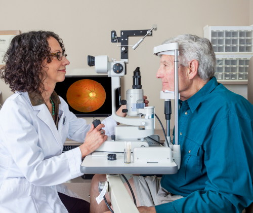 An optometrist provides an eye exam to a senior patient